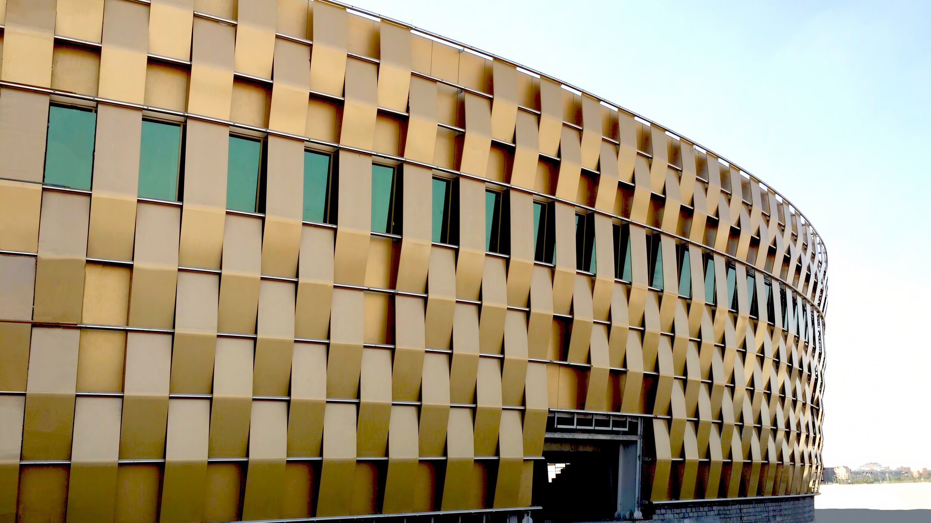 The curved gold-colored facade of King Faisal University’s Physical Education Building