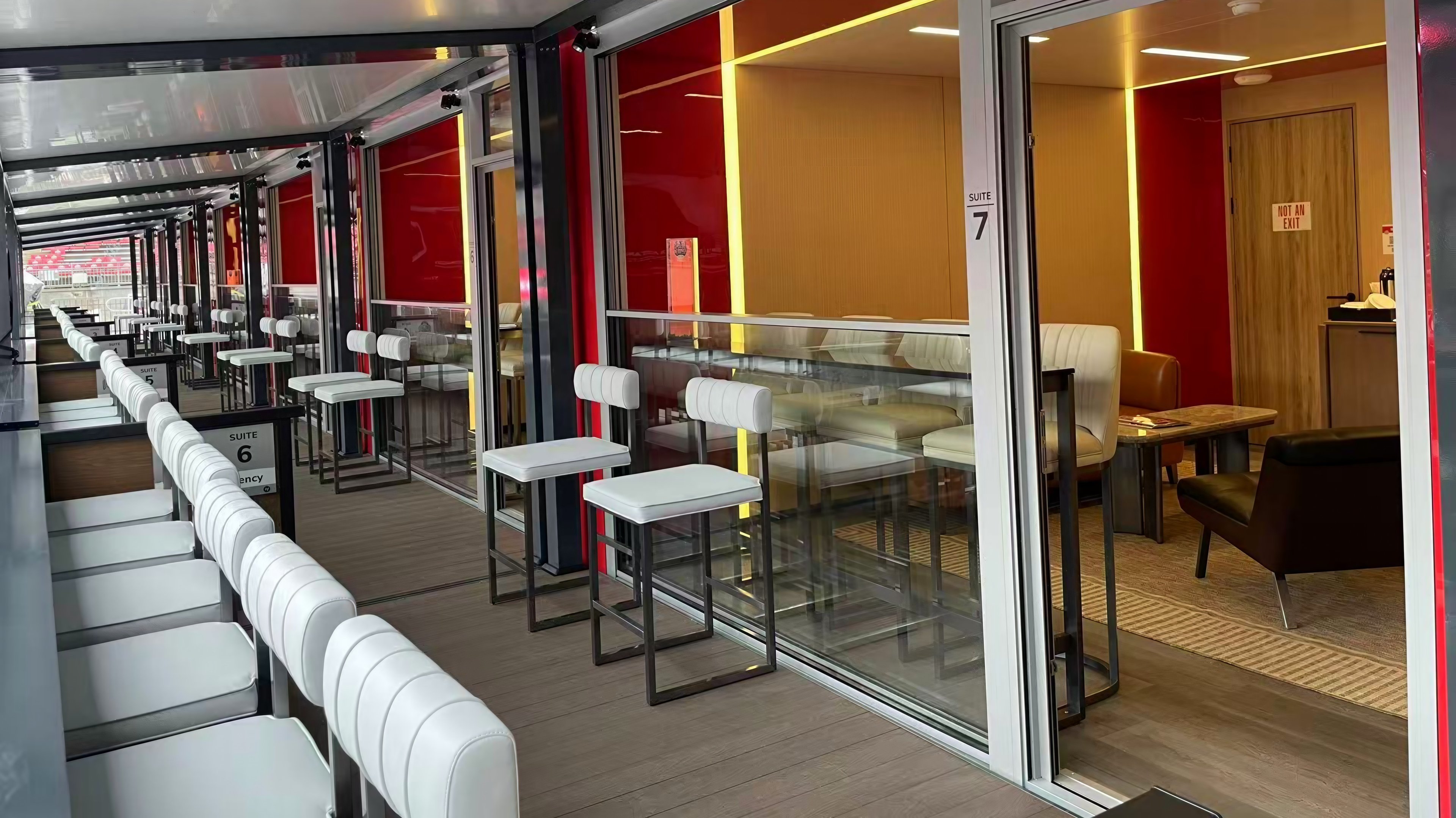 Covered VIP suite terrace with seating and glazed doors opening into the interior
