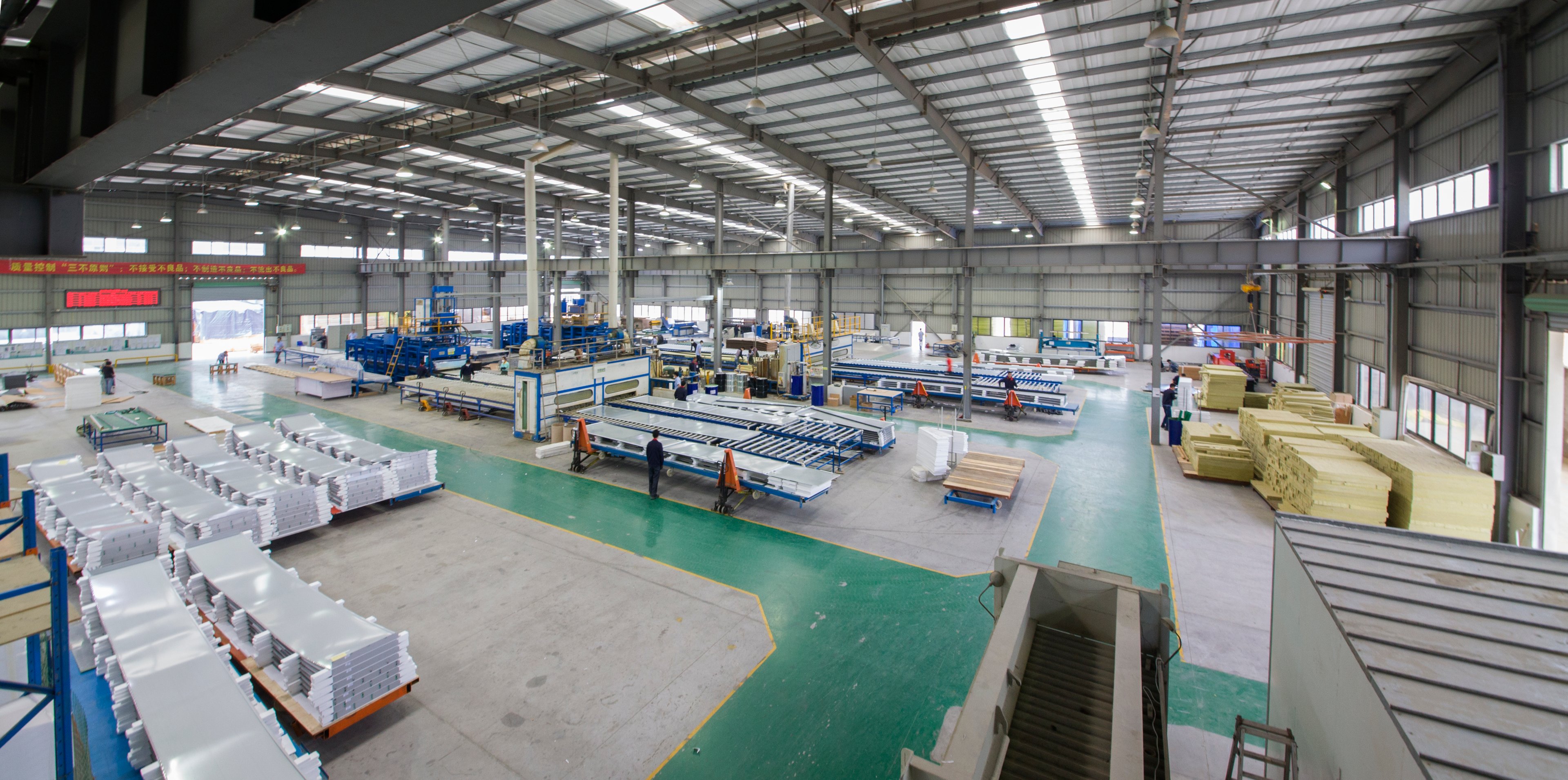 A wide view of the Winsom production floor, with machinery, work areas and stacked panels