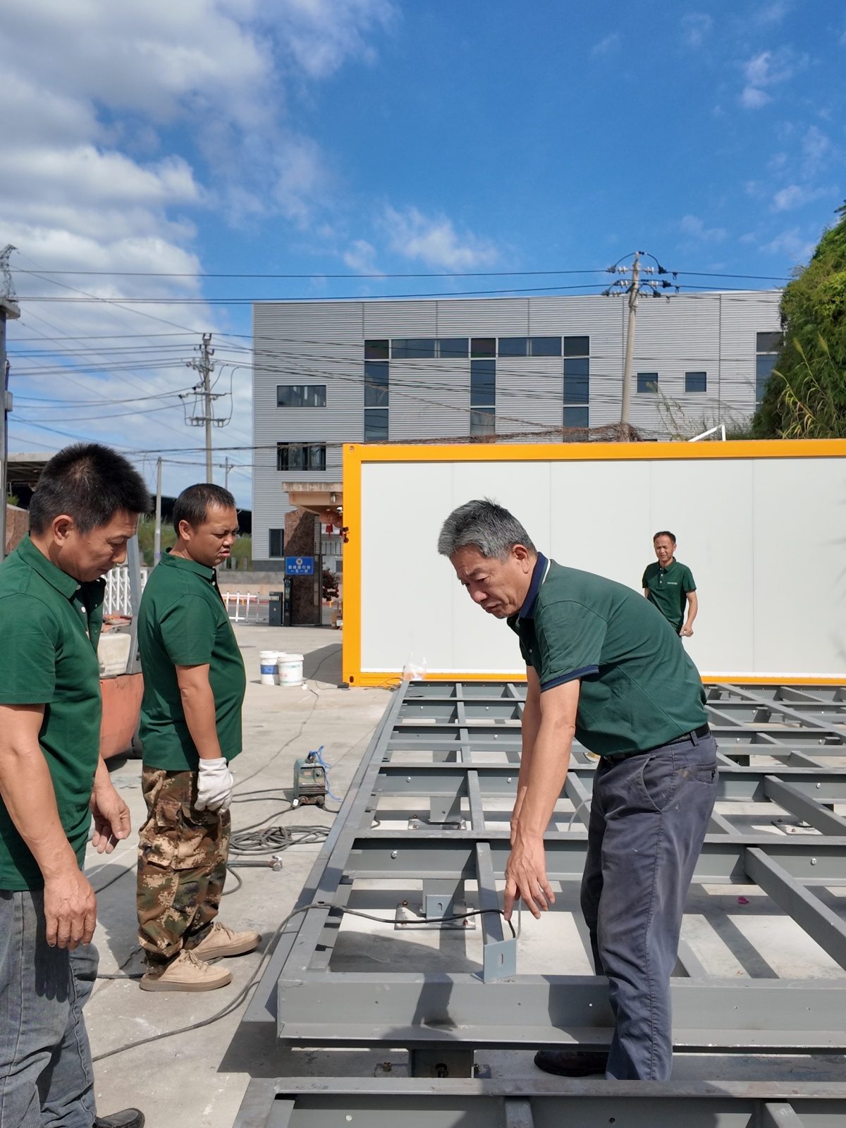 Assembly crew positioning the steel floor frame on the prepared site