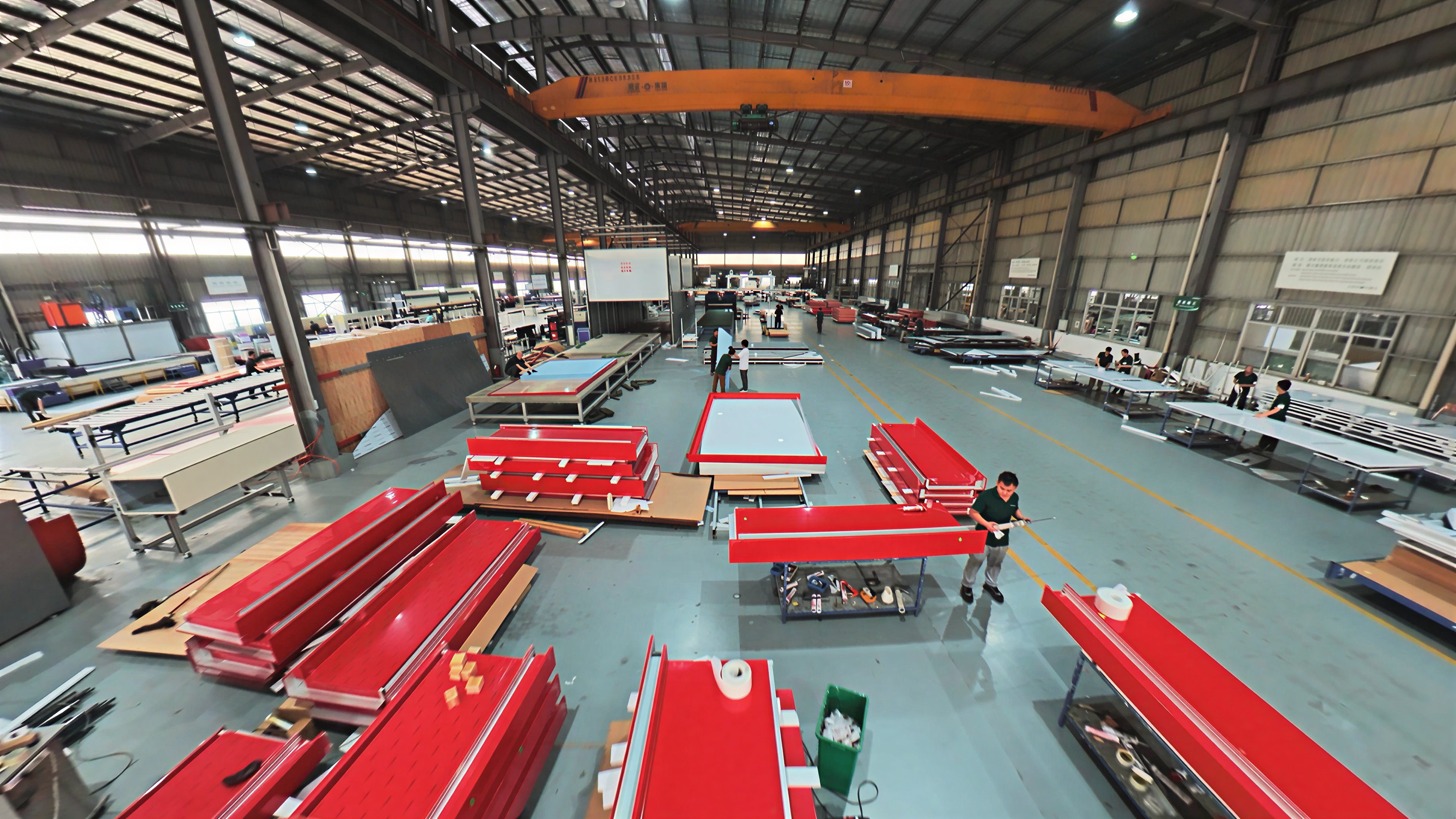 Factory workers preparing building panels and frames on the production floor